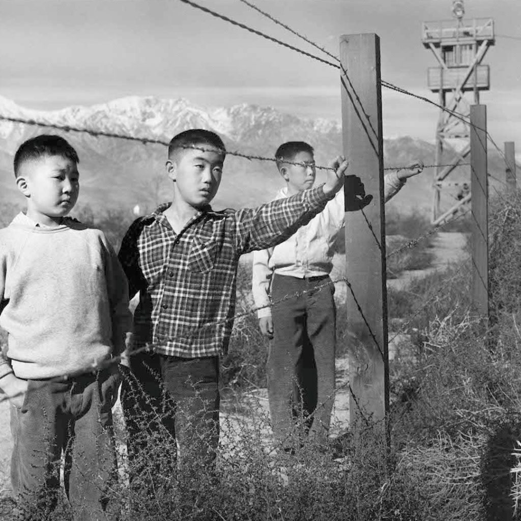 "Three Boys Behind Barbed Wire" by Toyo Miyatake, 1944, credit Toyo Miyatake Studio