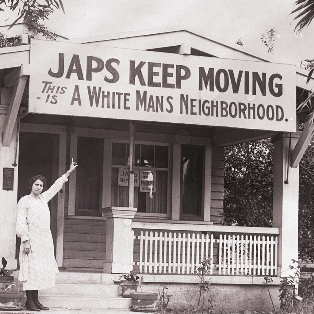 A California woman points towards an anti-immigrant sign posted outside her home, credit National Japanese American Historical Society