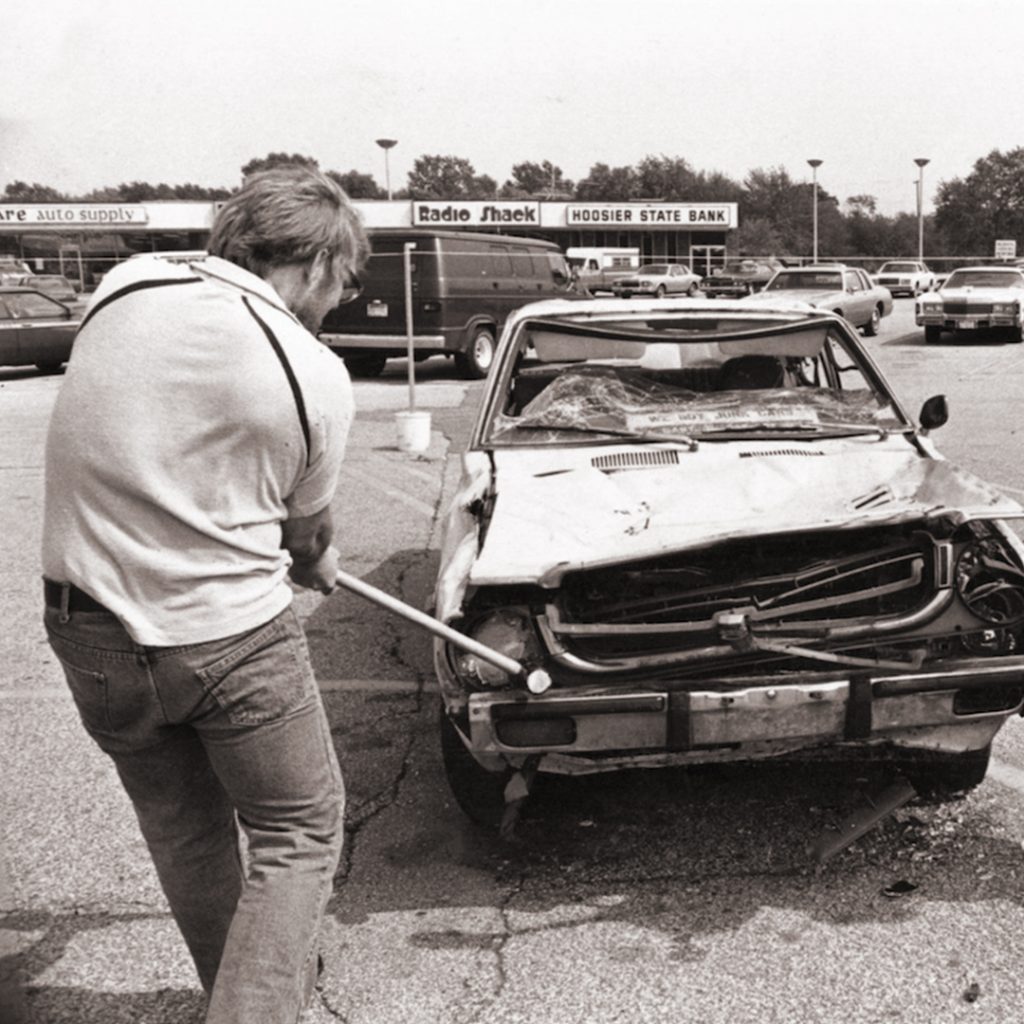A local businessman destroys a Japanese car. “Japan bashing” was prevalent in the 80s. They could have blamed the Germans too, but didn’t. Wonder why.