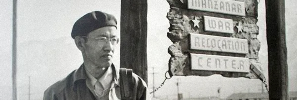 Toyo Miyatake in front of the Manzanar sign