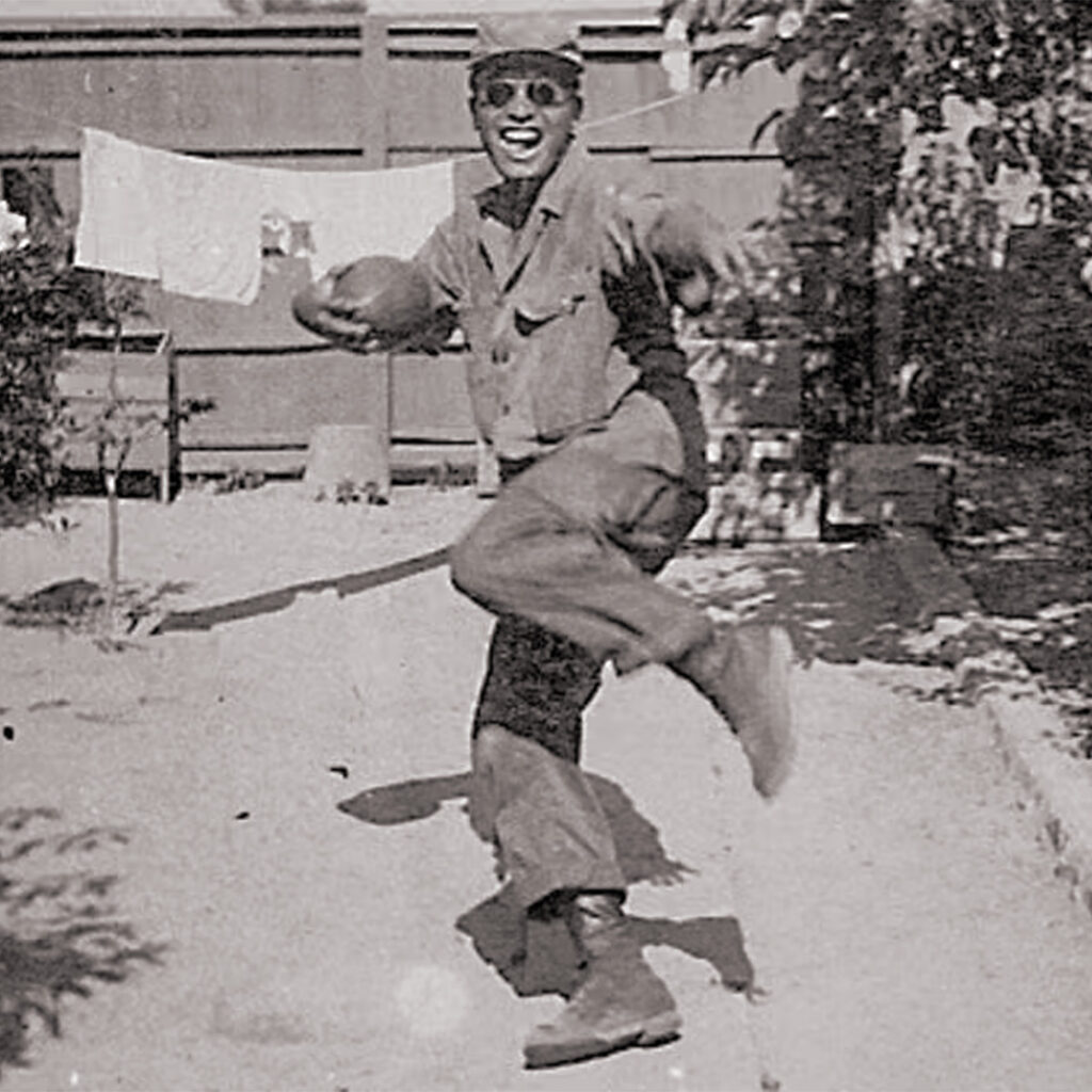 Horse Yoshinaga during his Army service posing with a football.