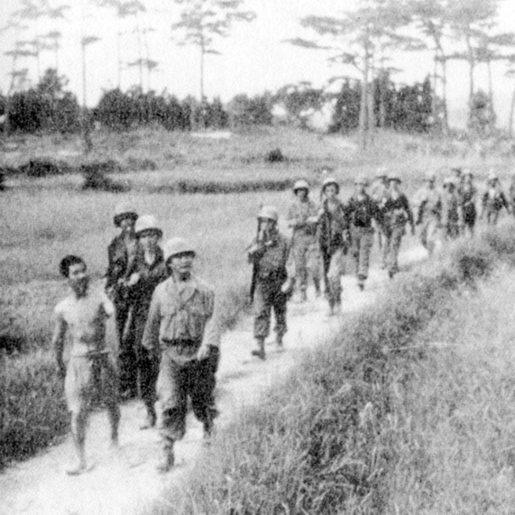 Lietenant Wally Amioka and a Japanese POW lead an American patrol, July 1945, credit National Archives
