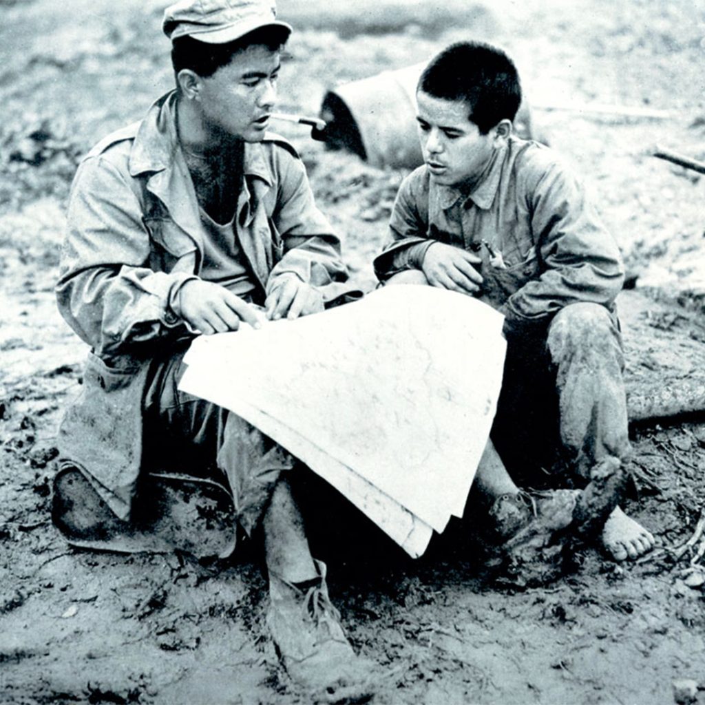 Warren Higa, left, questions a prisoner about Japanese positions, Okinawa, 1945, credit U.S. Army Signal Corps photo