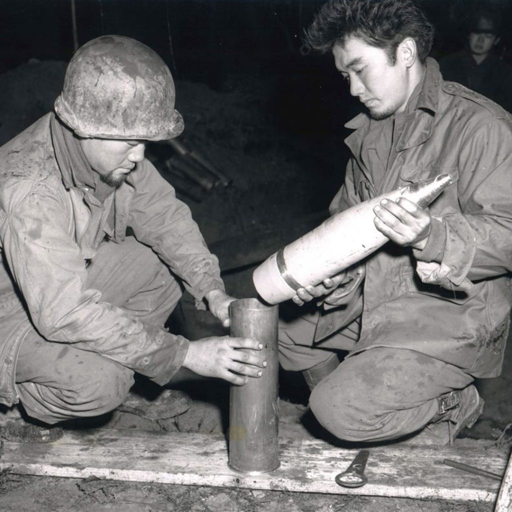 Two Nisei soldiers loading 105mm artillery shells for firing, Bruyéres, France, October 9, 1944, credit National Archives