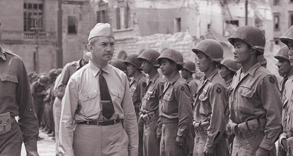 Lieutenant General Mark Clark and C.G. Fifth Army and Secretary of the Navy James Forrestal inspect troops from the 100th Infantry Battalion, Leghorn, Italy