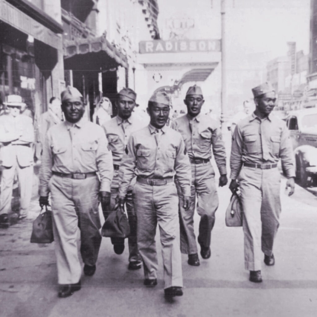 Sgt. Joe Takata (far right) and fellow 100th Infantry Battalion soldiers walking through Minneapolis, 1943.