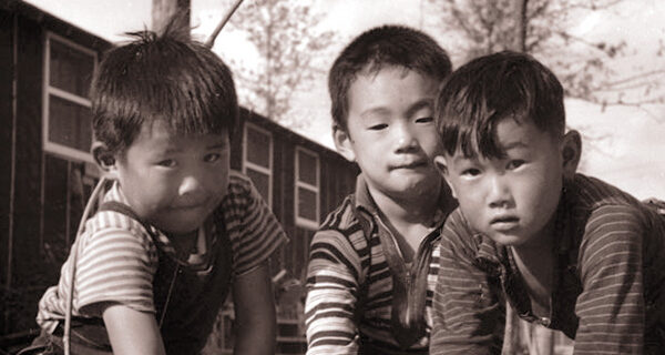 Chuck Koyanagi with other boys playing marbles, Rohwer War Relocation Center, Arkansas