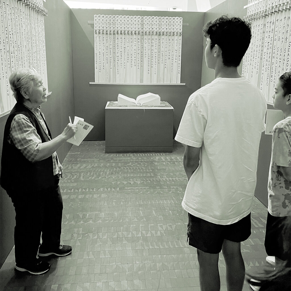 A volunteer at the Japanese American National Museum (JANM) instructing the camp descendants on how to honor names in the Ireicho. Photo by Phil Mimaki.