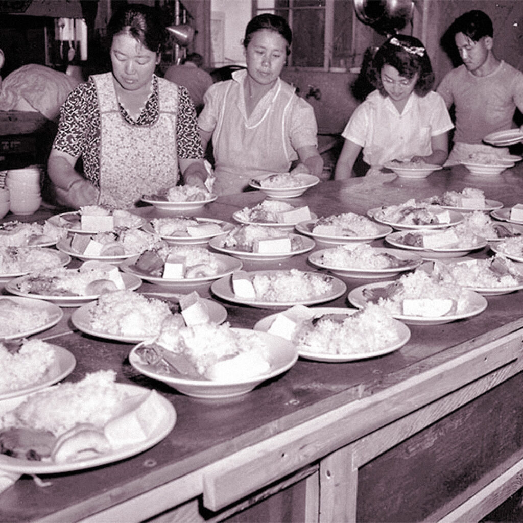 June 6, 1943: Food being prepared at Poston Japanese Relocation Camp. These servings consist of pork, rice with gravy, cucumbers and soy bean cake. This photo was published in the June 10, 1943 LA Times.