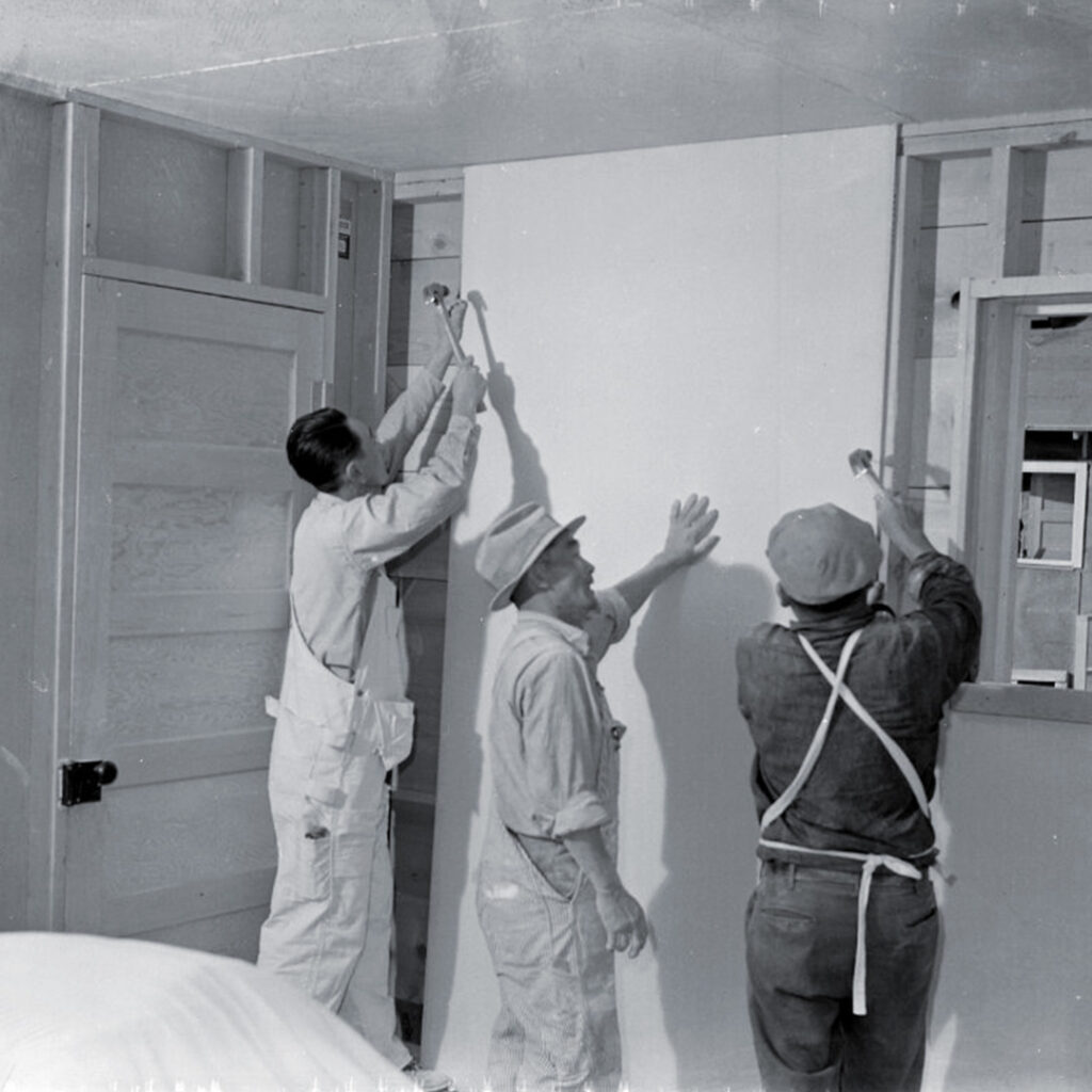 Volunteer carpenters work on the unfinished interior of a barrack at the Topaz War Relocation Center.
