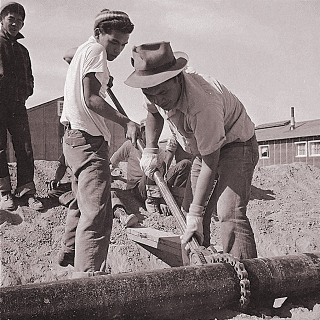 Workers connect sections of the water main at Topaz.