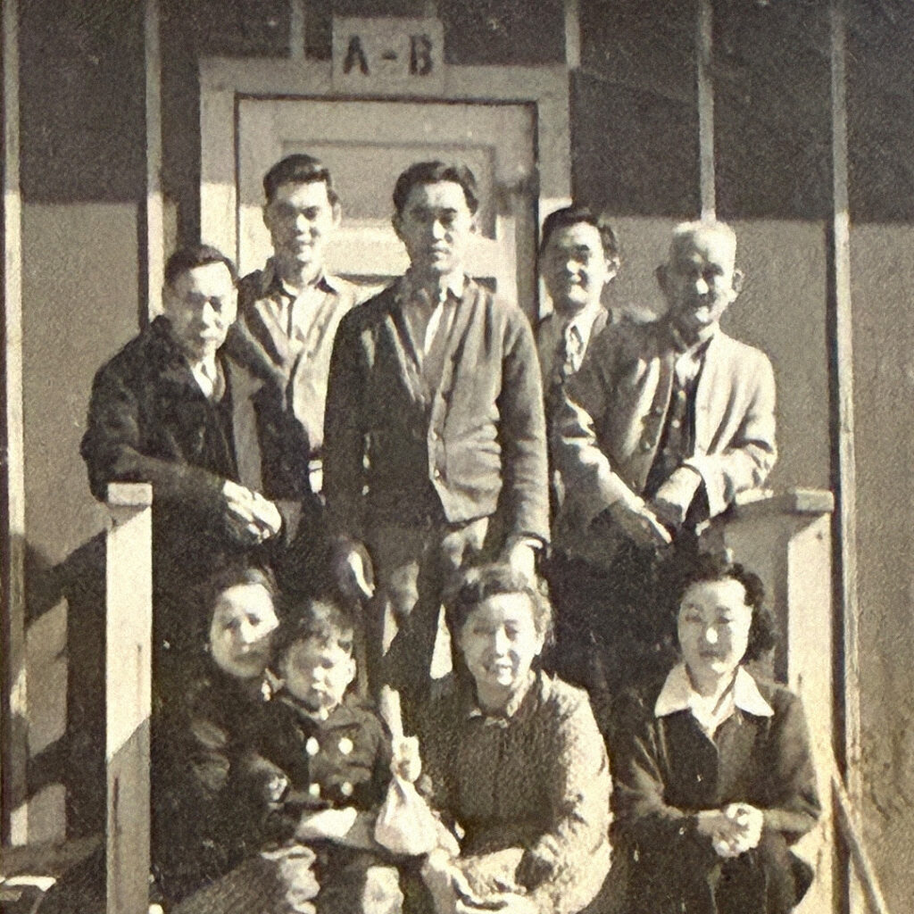 Claude Mimaki (standing center) with family and friends at Heart Mountain, likely taken just before he left the camp to begin military training with the MIS.