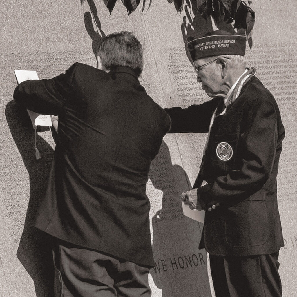 A Japanese American veteran from the Military Intelligence Service, Hawaii, tracing a name at the National Japanese American Memorial to Patriotism During World War II.