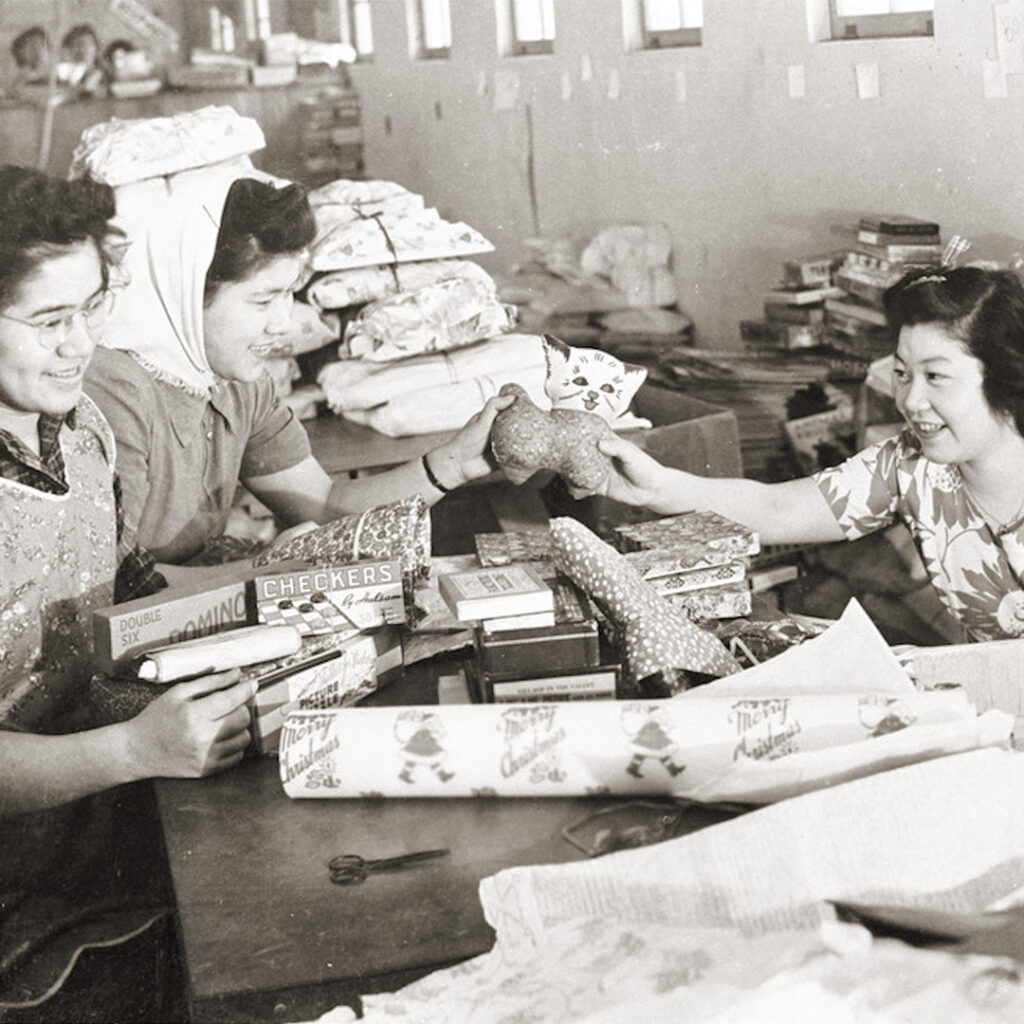 Women wrapping donated Christmas gifts inside camp, Minidoka, 1943.