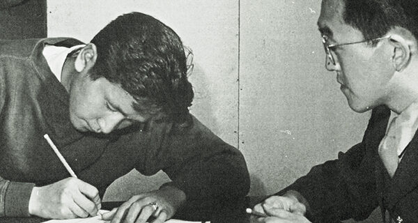 Young Nisei man completing questionnaire before enlisting, Amache, Colorado, photo by Tom Parker, courtesy of UC Berkeley Bancroft Library