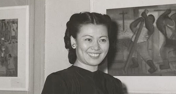 Mine Okubo standing by her art, courtesy of UC Berkeley, Bancroft Library